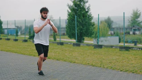 Young Adult Does Standing Lunges Outdoors