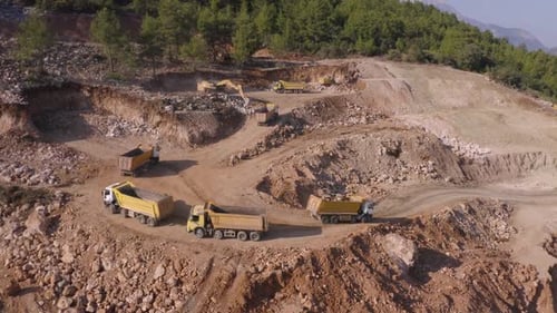 Panorama-Luftaufnahme von Muldenkippern, die auf der Quarry Road im Berggebiet fahren