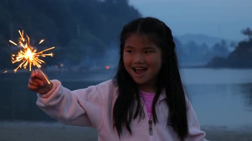 Happy Girl Sparkler on Beach at Dusk