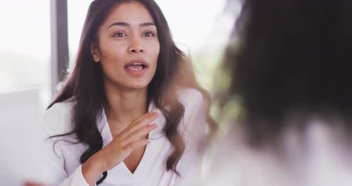 Professional businesswoman talking to her colleagues while sitting in modern office in slow motion