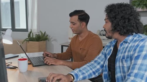 Indian Programmers Talking while Working on Computers