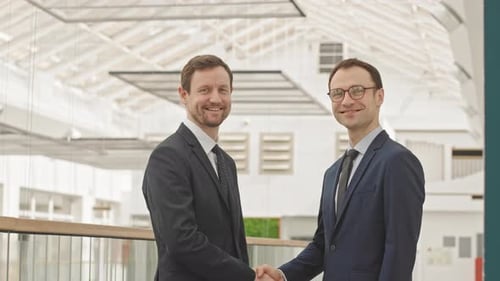 Men in Suits Handshake in Modern Office