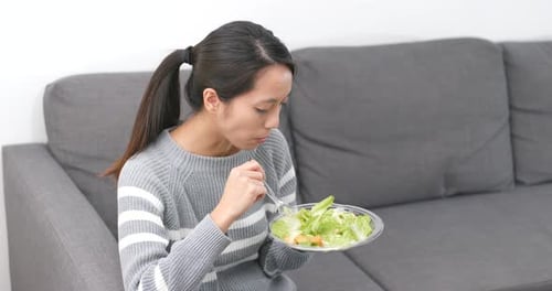 Woman Eating Healthy Salad on Couch Indoors