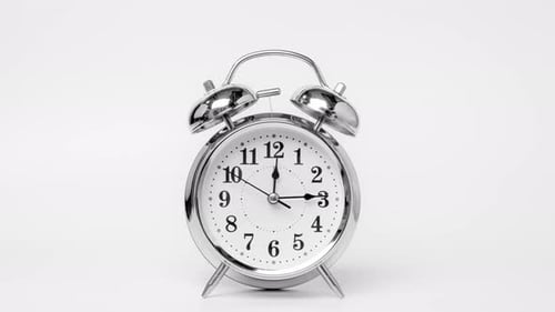 Time lapse of retro alarm clock running isolated on white background. T