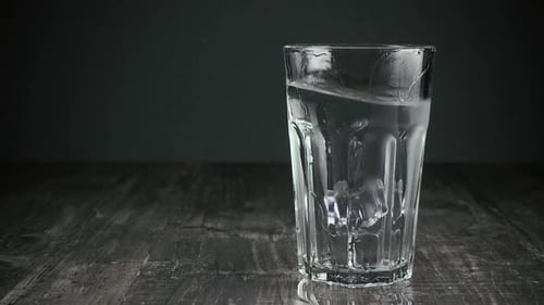Ice Cubes Dropping into Glass of Water