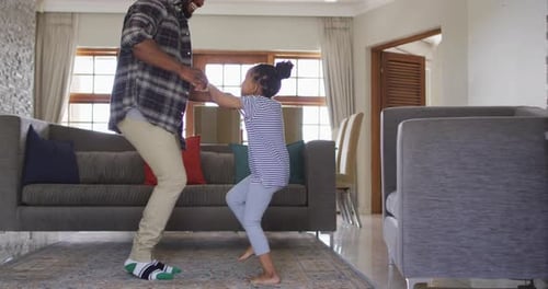 Father and Daughter Dancing Together at Home