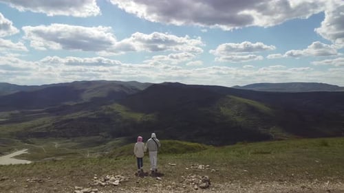 Couple of Travelers Go Hand in the Mountains Enjoying the Beautiful Scenery