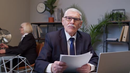 Senior Business Company Manager sitzt am Schreibtisch und liest Lebenslauf Erfolgreiches Vorstellungsgespräch