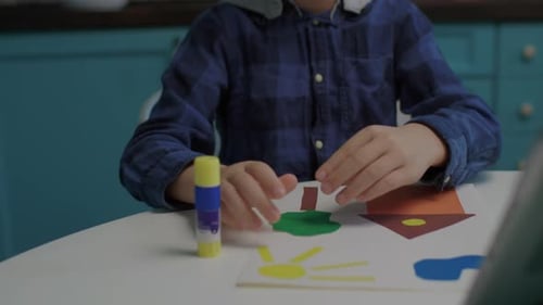 Close Up of Creative School Boy Making Art Applique with Color Paper and Glue