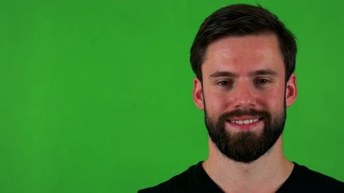 Young Handsome Bearded Man Smiles To Camera - Green Screen - Studio - Closeup
