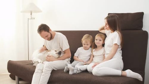 Happy Family with Dog Relaxing on Couch