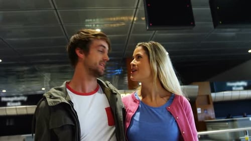 Couple Walking and Smiling in Modern Airport
