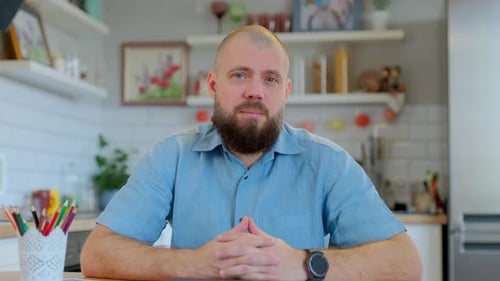 Bearded Man Talking To Camera at Home