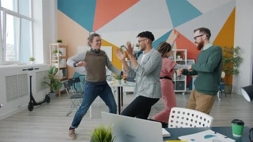 Playful Girl and Guys Dancing in Office Having Fun During Business Party at Work