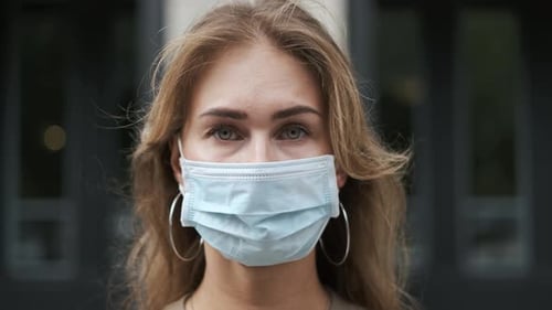 Woman Wearing a Blue Surgical Mask Close Up