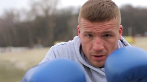 Boxer Training Outdoors with Blue Boxing Gloves