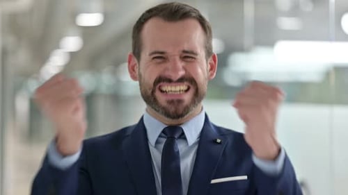 Man in Suit Pumping Fists in Celebration