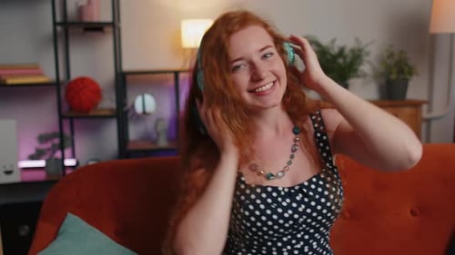 Woman with Headphones Listening to Music at Home