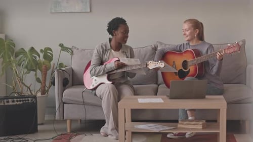 Friends Play Guitars Together in Living Room