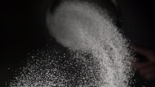 White Powder Falling from a Sieve in Close-up