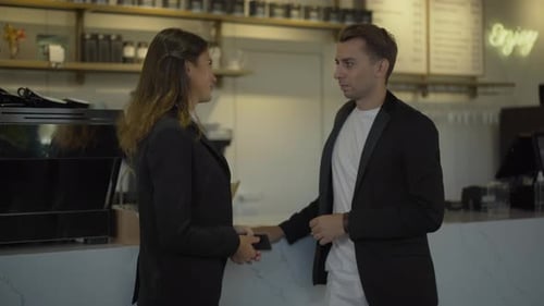 Young Confident Man and Woman Talking at Counter in Cafe. Side View Portrait of Caucasian