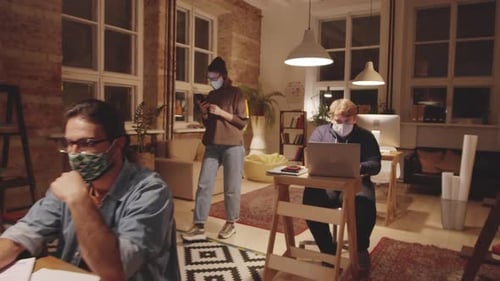 Young Employees in Masks Working in Loft Office in Evening