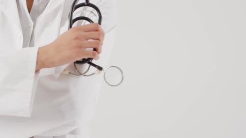 Medical Professional Holds Stethoscope in Clinic