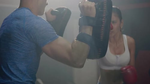 Woman Boxing in Gym with Trainer