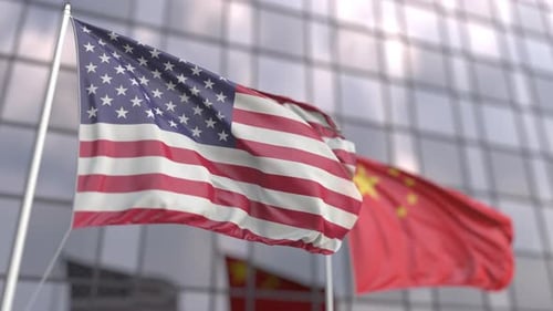 United States and China Flags Waving on Modern Building
