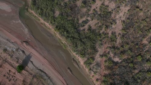 Aerial view looking down at river flowing through the desert