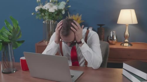 Man Works on Laptop in Home Office