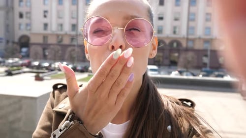 Woman Smiling and Waving in Urban Environment