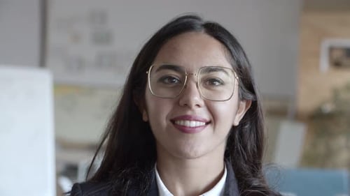 Smiling Woman Wearing Glasses in an Office