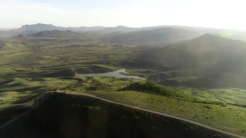 Green forested hills and small lake