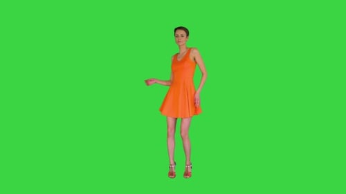 Short-haircutted Pretty Woman Dancing in Orange Sundress on a Green Screen, Chroma Key