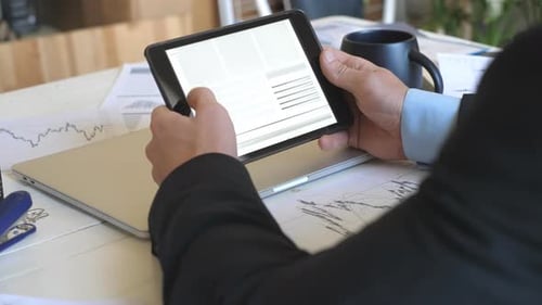 Adult Using Tablet Showing Business Data