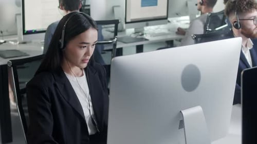 Woman with headset working at computer in office