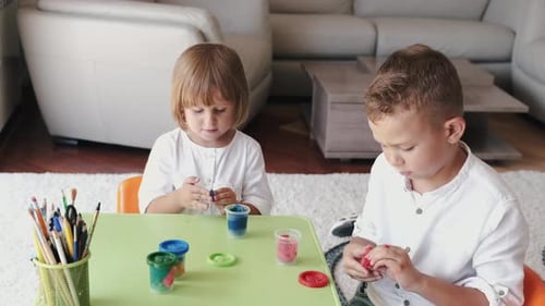 Children Play with Colorful Modeling Clay at Table