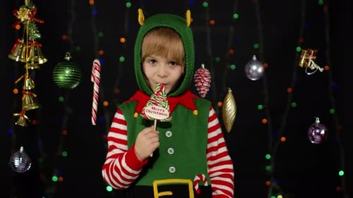 Festive Child Dressed as Christmas Elf with Lollipop