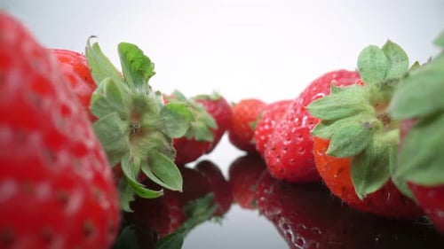Reife frische natürliche Erdbeeren im Spiegelbild in extremer Makro-Nahaufnahme