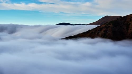 Cloud Inversion Clouds Spill Over the Mountain Waterfall From the Clouds