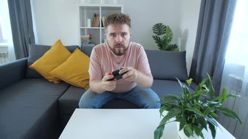 Man Plays Video Game on Console at Home