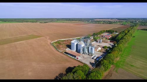 Lagersilos auf dem Bauernhof. Luftaufnahme des Getreidesilos im grünen Feld