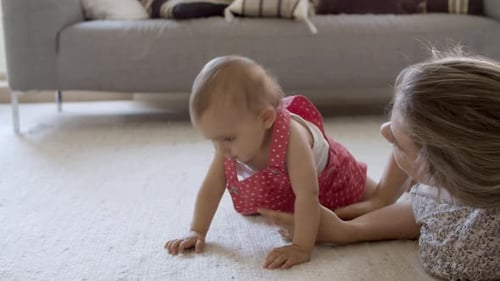 Adorable Baby Crawling with Help from Adult