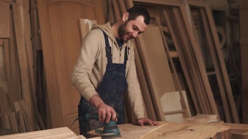Man sands wood in woodworking shop