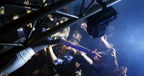 Woman Crowd Surfing at Night Music Event
