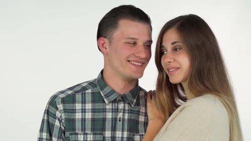 Affectionate Young Couple Embraces and Poses Smiling