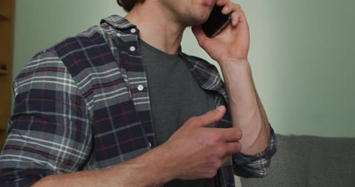 Man Talking on Phone Wearing Plaid Shirt Indoors