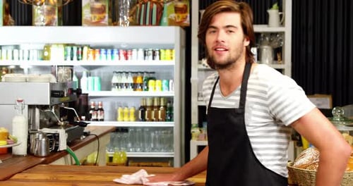 Smiling Barista Cleaning the Cafe Counter