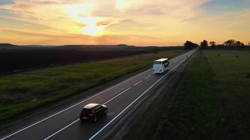 Drohnenaufnahme: Weißer Touristenbus, der für eine Reise wegfährt